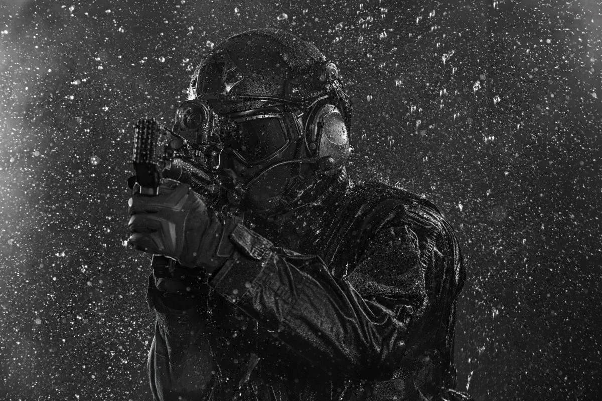 Operador tático sob chuva com equipamento de visão noturna
